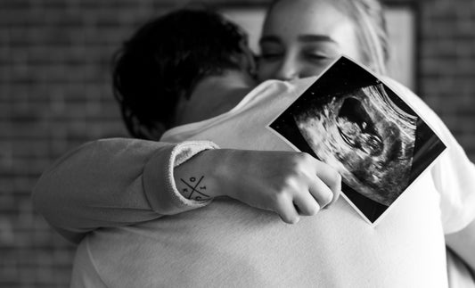 Couple ému et heureux se tenant une photo d'échographie de leur bébé