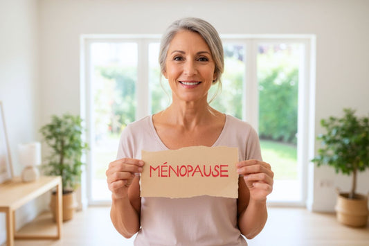 Portrait souriant d'une femme d'âge mûr tenant une pancarte "MÉNOPAUSE"