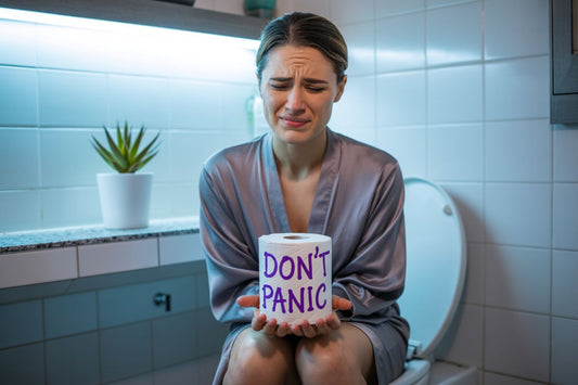 Femme paniquée sur les toilettes tenant un rouleau de papier WC avec écrit Don't Panic