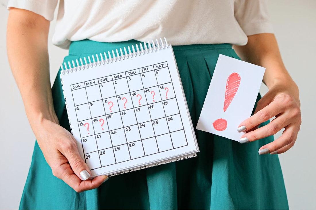Calendrier menstruel avec points d'interrogation, symbolisant l'irrégularité du cycle féminin