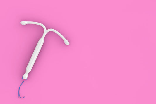 Un stérilet hormonal blanc sur un fond rose