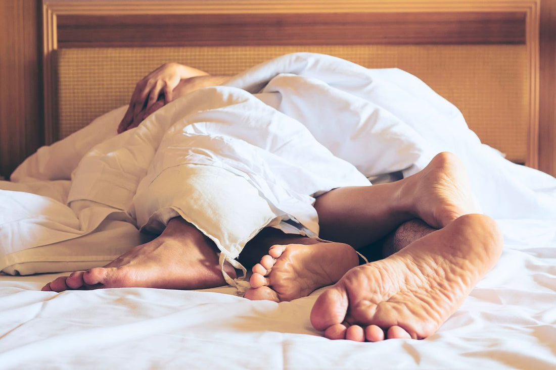 Pieds de deux personnes sous la couette