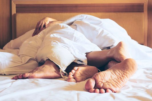 Pieds de deux personnes sous la couette