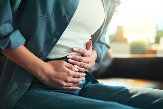 Femme se tenant le ventre à cause de douleurs liée au syndrome prémenstruel (SPM)