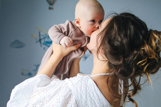 Kobieta trzymająca dziecko, ilustrująca różnicę między powrotem do pieluszek a powrotem do miesiączki po porodzie
