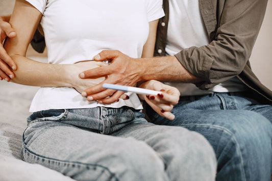 Couple tenant un test de grossesse pour tomber enceinte avant le retour de couches