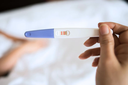 ain tenant un test de grossesse positif affichant deux barres rouges claires