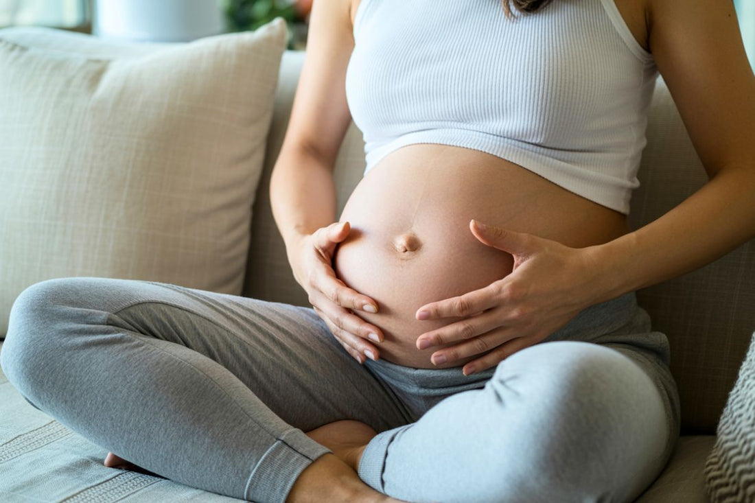 Gros plan sur une femme enceinte tenant son ventre alors que son ventre durcit