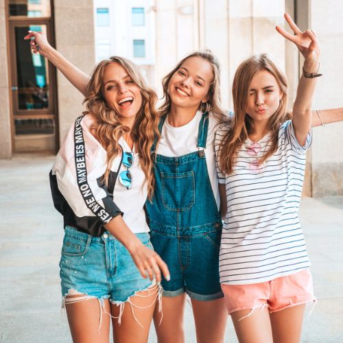 Un gruppo di adolescenti sorridenti e sicure di sé stanno insieme, esprimendo la libertà e la facilità di vivere il proprio ciclo mestruale senza costrizioni