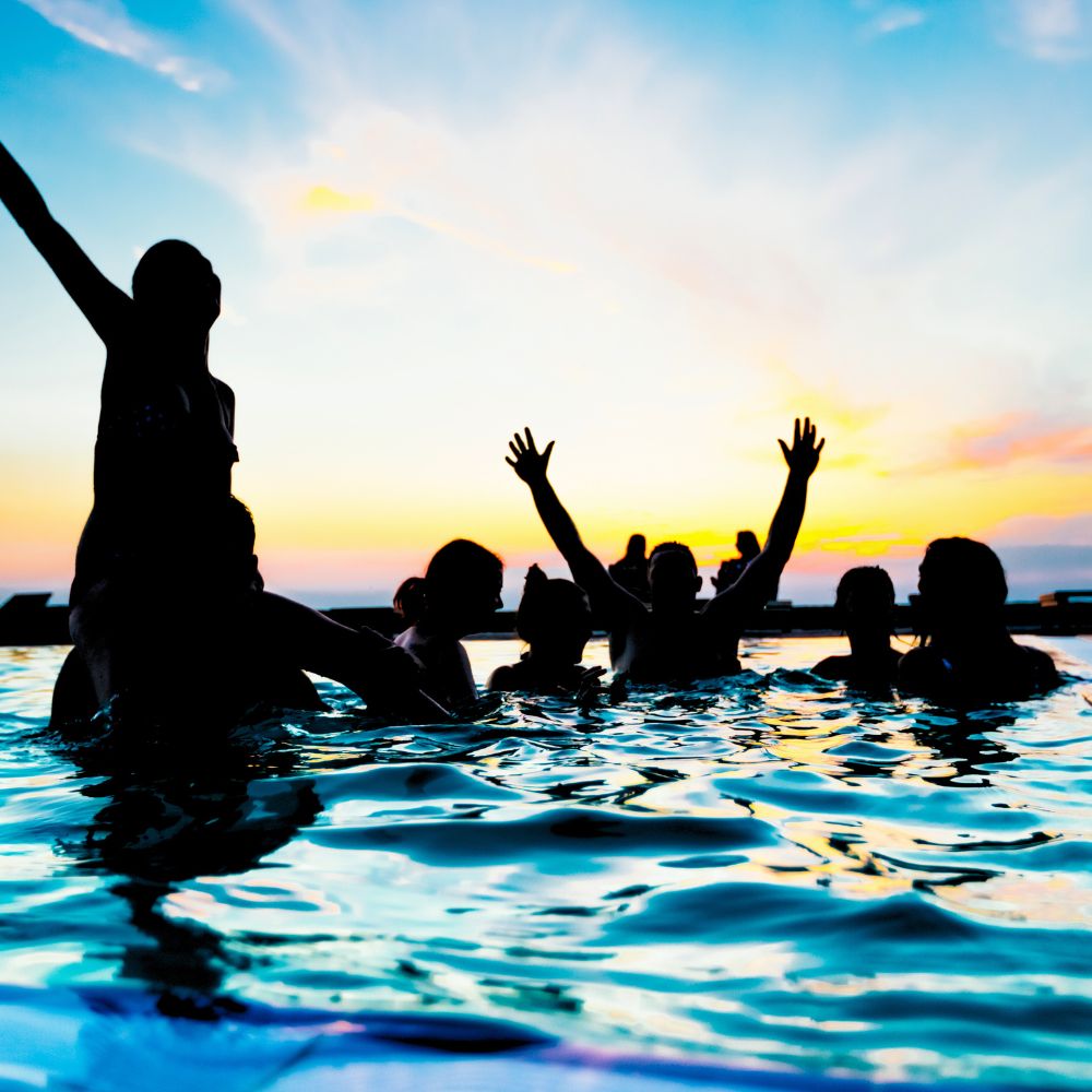 Grupa nastolatków korzystających z kąpieli o zachodzie słońca